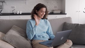 Happy hispanic teen girl talking using laptop computer enjoying online virtual chat video call with friends or family in distance e chat virtual meeting using pad computer sitting on sofa at home.