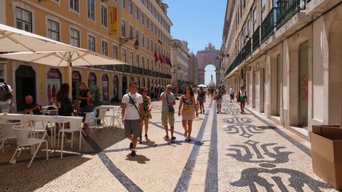 LISBON - JULY 18, 2019: Sunny and hot weather in Lisbon city, first person view walk along famous shopping and dinning pedestrian street, Rua Augusta. Unidentified tourists ramble around