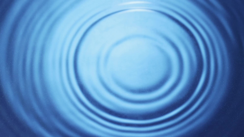 Top view of drop falls into water and diverging circles of water on blue background in slow motion Royalty-Free Stock Footage #1066145443