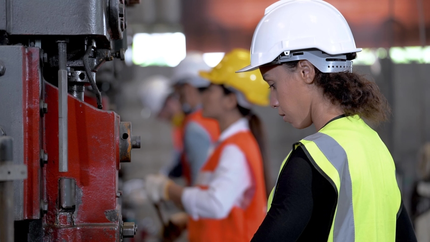 Workers factory Brazilian woman working at heavy machine. group of people operating in front of engine manufactured at industrial steel plant factory. | Shutterstock HD Video #1066146061