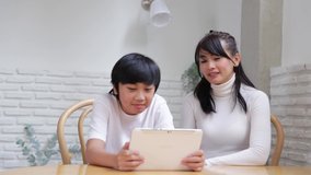 Happy Asian family talking video conference by computer together in living room , New normal lifestyle and activity technology, social distancing concept