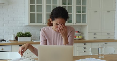 Confused young caucasian woman reading email on computer, taking off eyewear, feeling depressed of getting bad news online, professional exam failure, receiving dismissal notice, lost job concept.