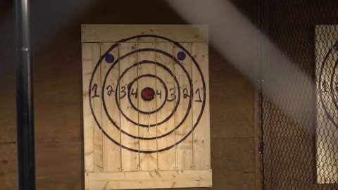 Axe throwing target cages with two people throwing axes in slow motion