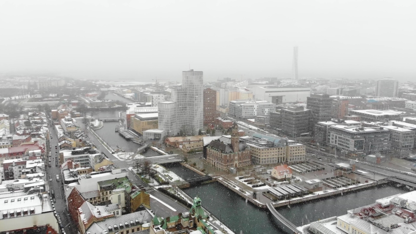 Cinematic circling over snowing Malmö with drone. Clarion hotel, turning torso, Malmo university, World Maritime University