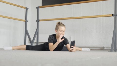 A handsome young guy is engaged in yoga and communicates online via video communication. The concept of sports and meditation. Stretching and yoga workout.