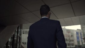 MIxed race businessman walking briskly towards office building