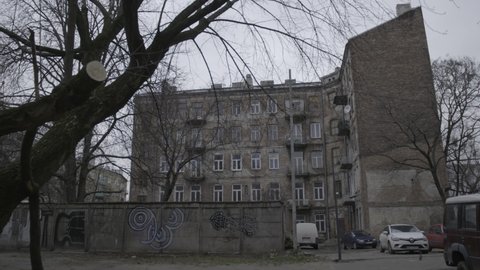 Camera panning in an old Jewish Ghetto courtyard, some of the buildings are populated again, and have some graffiti on them, a 4K (Sony S-Log) video clip, February 25th, 2020, Warsaw, Poland.