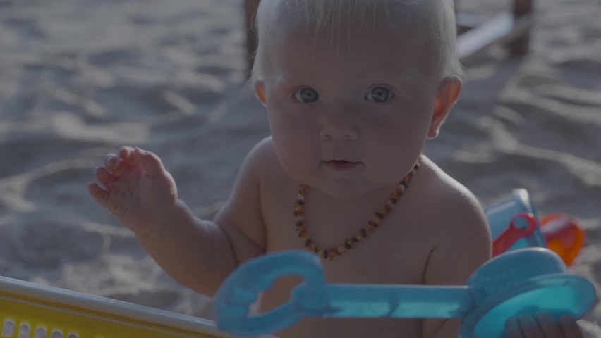 Baby girl enjoying her time on the beach during the summer holiday | Shutterstock HD Video #1066172452