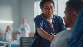 Hospital Ward: Friendly Black Head Nurse Uses Stethoscope to Listen to Heartbeat and Lungs of Recovering Male Patient Resting in Bed, Does Checkup. Man Getting well after Successful Surgery - Powered by Shutterstock - Get 15% off with code: PIKWIZARD15