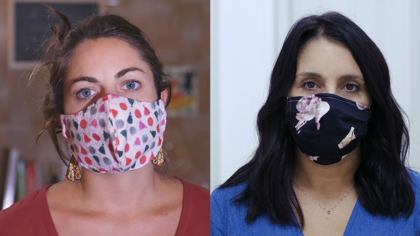 portrait of two young women rejoicing by removing their mask and smiling at camera