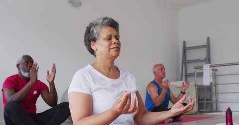 Diverse group of seniors taking part in meditation class. health fitness wellbeing at senior care home., videoclip de stoc