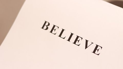 "BELIEVE" word printed on the sheet paper.