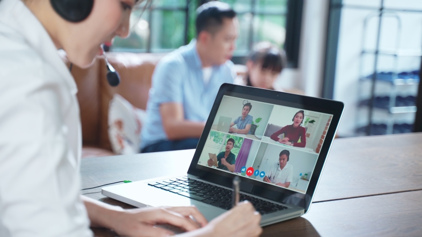 Asian business woman talking to colleague team about plan in video conference. Group of business people using computer for online meeting in video call conference. Smart working from home with family. | Shutterstock HD Video #1066181338