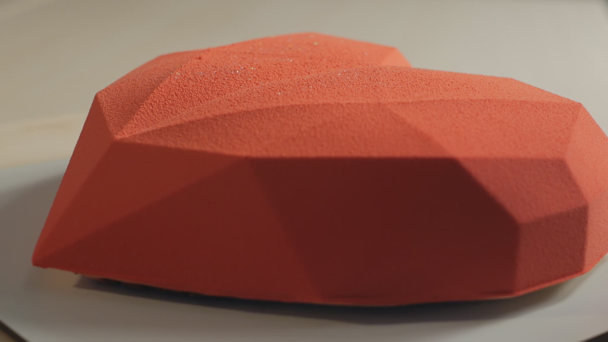 Red cake in the form of a heart rotation. Heart cake. Dessert and Valentine