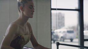 Reflection of ballerina in dance studio stretching leg on ballet barre , Lehi, Utah, United States