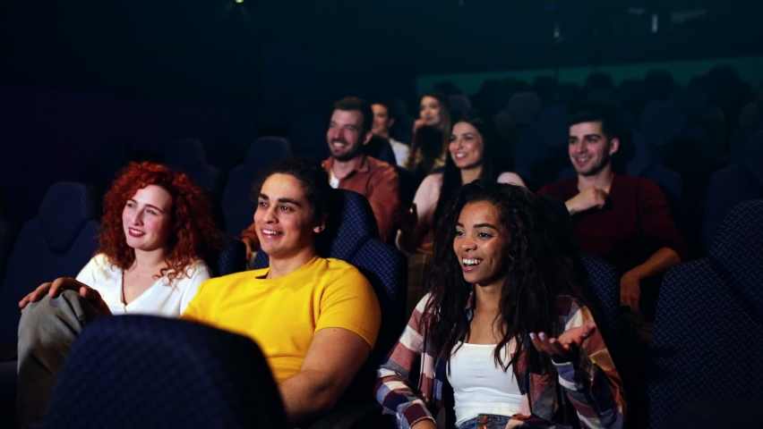 Group of cheerful people laughing while watching movie in cinema. Royalty-Free Stock Footage #1066199569