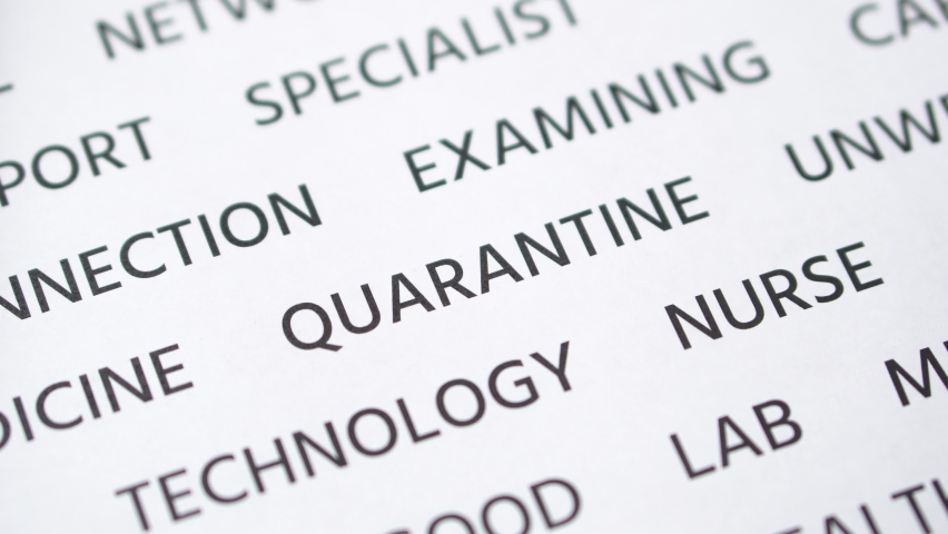 Hand crosses out in red marker the word quarantine written on white paper. Close-up