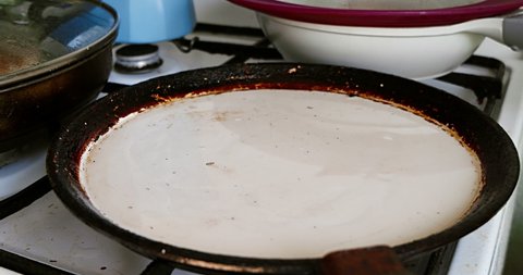 Frying pancakes in butter on shallow pan. Homemade cakes preparation.