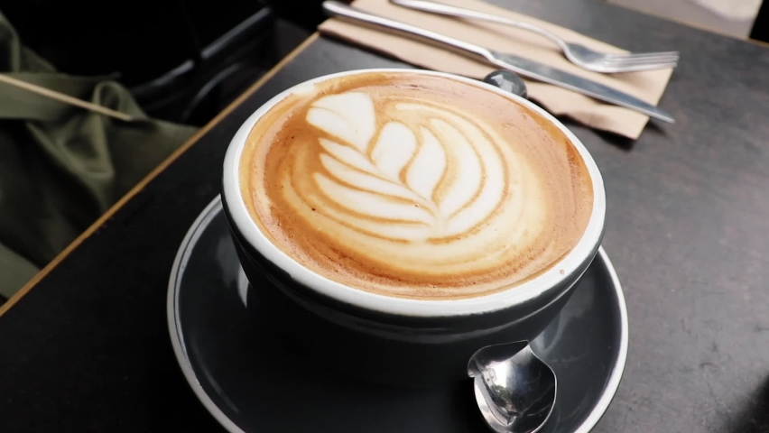 Latte art of tulip in coffee shop for breakfast in Australia with a black mug. The coffee art in Australia was great and the lattes were delicious.