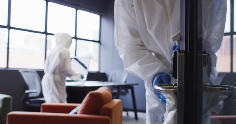 Cleaners wearing protective clothes sanitizing modern office space. hygiene in business workplace during covid 19 coronavirus pandemic.