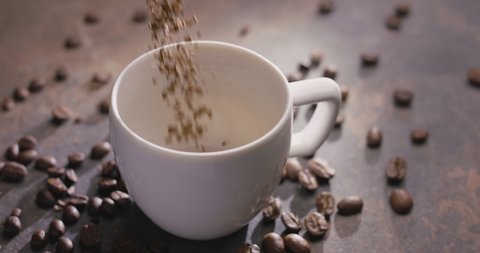 Instant coffee granules are poured into a white cup, then boiling water is poured, slow motion, macro top view. 300fps, Blackmagic Ursa Pro G2. 