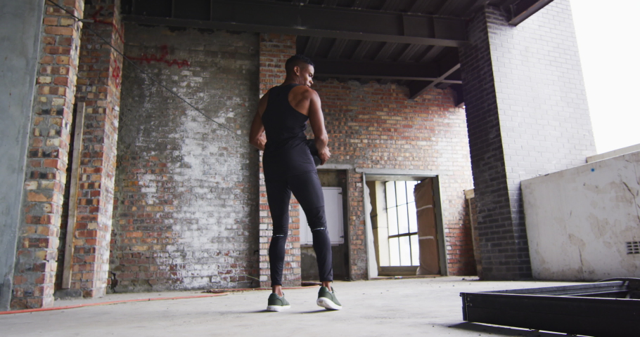African american man exercising with medicine ball in an empty urban building. urban fitness and healthy lifetyle.