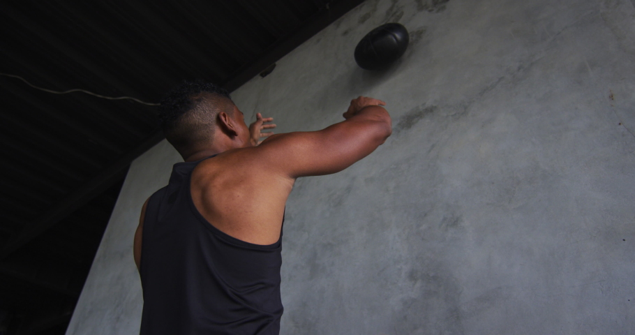 African american man exercising with medicine ball in an empty urban building. urban fitness and healthy lifetyle.