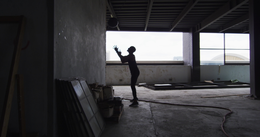 African american man exercising with medicine ball in an empty urban building. urban fitness and healthy lifetyle.