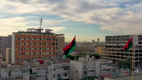 Tripoli, Libya - December 27, 2020: Libyan flag flying over the capital of Libya, Tripoli.
Tripoli skyline view.