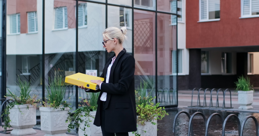 A beautiful girl checks documents in a large yellow folder and dances with joy. Dance with a folder of documents.