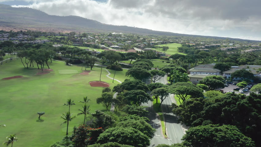 Luxury resort style residential neighborhood with golf course access. Aerial view of road in the prestige village with golf club and green park view. Maui landscape, Hawaii, USA. Modern villas houses