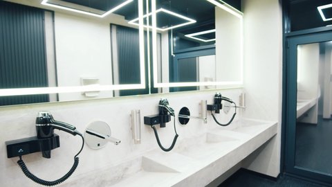 At the modern gym. Empty bathroom white area in the gym. Toilet with wash basins and mirrors at the fitness club without people. Sport, interiors, entrance, bathroom, hall, quarantine concept