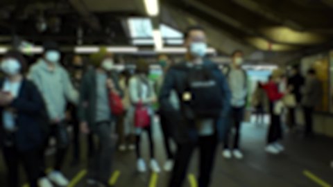SHINJUKU, TOKYO, JAPAN : Crowd of people at railway or train platform. Commuters waiting for train in busy morning rush hour. Japanese city life and transportation concept. Blurred slow motion shot.