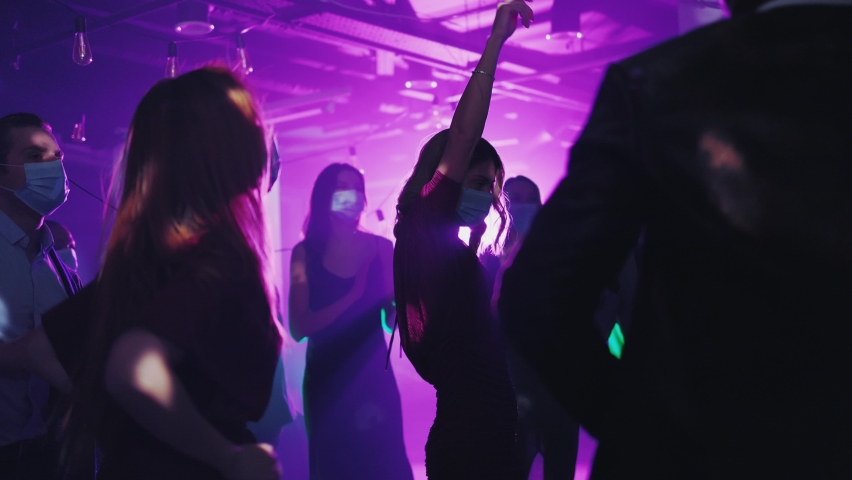Happy Multi-Cultural Young People Coworkers Wearing Healthcare Medical Masks Social Distancing Dancing and Celebrating Christmas Corporate Party. Royalty-Free Stock Footage #1066239667