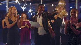 African Young Boss Talking Formal Speech on Business Party Congratulating Best Workers and Telling Successful News. Corporate Celebration. Night Hangout. - Powered by Shutterstock - Get 15% off with code: PIKWIZARD15