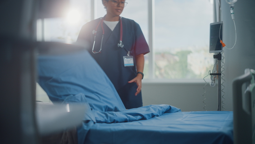 Hospital Ward: Beautiful, Professional Latin Black Nurse Working, Doing Bed, Cleaning Room After Happy Healthy Patients Recover and are Discharged Under Treatment of the Best Doctors. Sunny Room Royalty-Free Stock Footage #1066240969