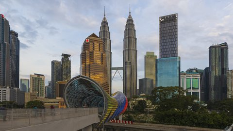 KUALA LUMPUR, MALAYSIA - FEBRUARY 7, 2020 : Time lapse: Kuala Lumpur city view overlooking the city skyline by the city attraction Saloma Link with busy pedestrian in Malaysia. Zoom in. Prores 4K