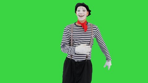 Mime artist smile and simulate walking on a Green Screen, Chroma Key.
