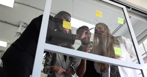Business team group meeting with sticky post on mirror glass board to brainstorming and sharing new idea in office