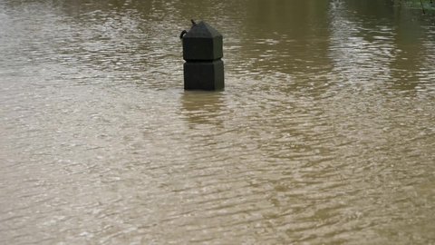 OXFORD, UK- January 21, 2021: Long Shot of Timber Bollard Almost Entirely Submerged In Flood