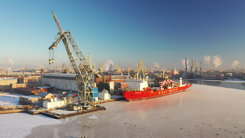 Aerial panoramic view of winter St. Petersburg, Russia. Label ship 
 translation: Rosatomflot, Russian navy. Port, ships in the harbor, docks. View from the Drone