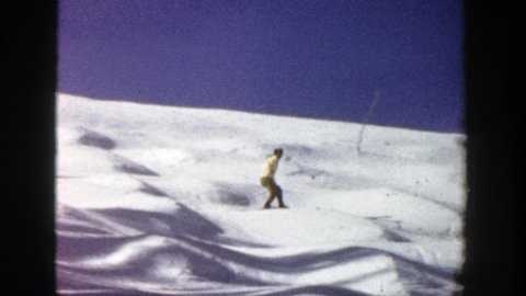 ASPEN COLORADO-1961: Adult Skiing Downhill Making Short Turns Over Small Hills On White Snow And Wearing A Yellow Jacket