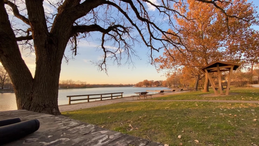Autumn fall colors in a park next to a lake in McHenry Illinois during sunset golden hour
