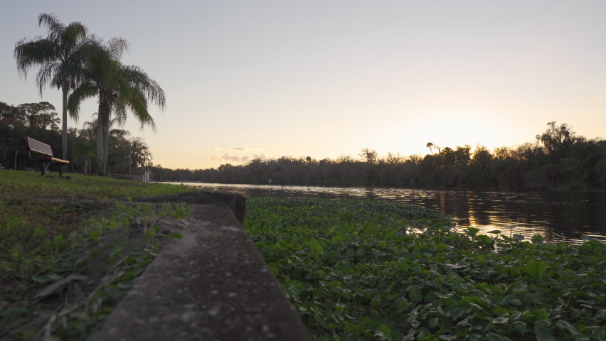 Park benches overlook the river at sunset. This park is on the banks of the famous St. Johns river. Its shot in 4K UHD at 24fps.