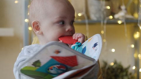 Little baby boy bitting a teether toy. Baby teething concept.