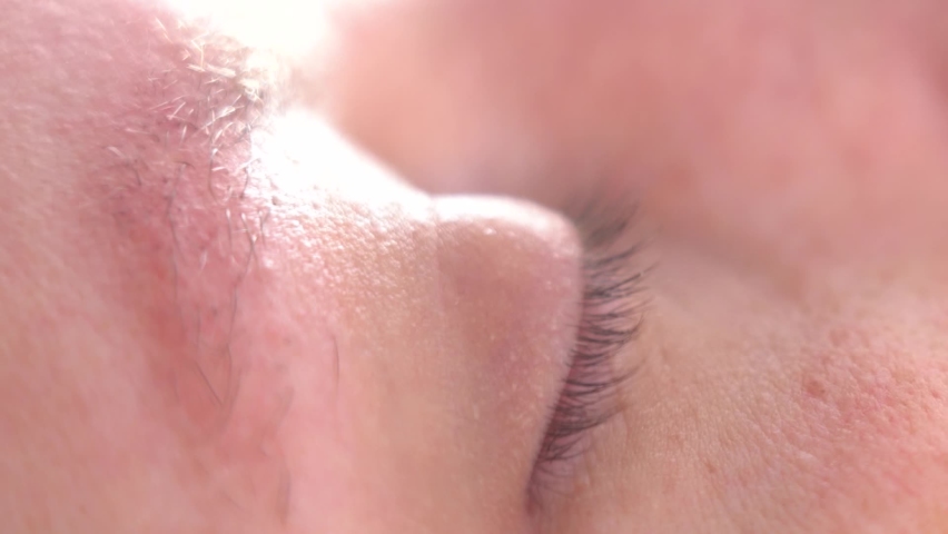 Close-up of the movement of the eyes during sleep. Man Sleeps and Dreams in Daylight. Healthy Sleep Concept. Blurred Video. Defocus Royalty-Free Stock Footage #1066286323