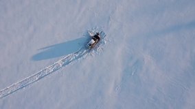 Car stuck in a snow field. Landscape of nature in a snowy day, aero video, top view of a car in winter