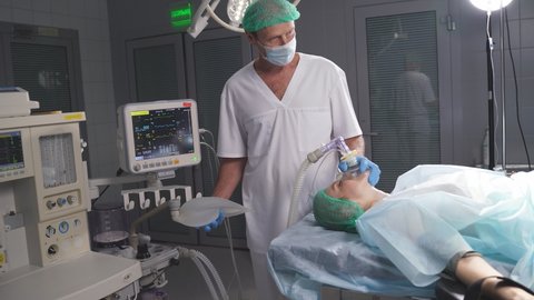 Anesthesiologist gives the patient an oxygen mask. Medical professional working in hospital. Anesthesiologist at work.