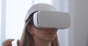 closeup portrait of young woman using HMD-display in home. moving hands for controlling, modern technology of video games and education.