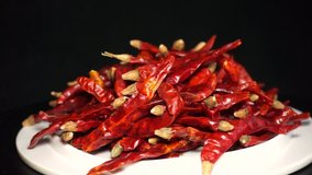 Dry red pepper, spicy cooking ingredients, rotating display video on black background.